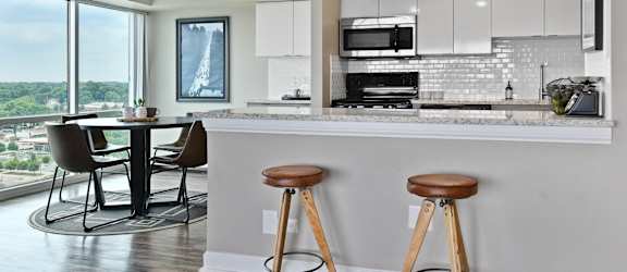 an open kitchen with a bar and stools in front of a window at CityView on Meridian, 3801 N. Meridian St, Indianapolis, IN 46208