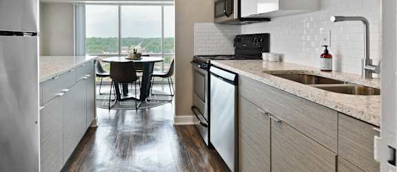 an open kitchen and dining area with a large window and a table with chairs at CityView on Meridian, 3801 N. Meridian St, Indianapolis, IN 46208