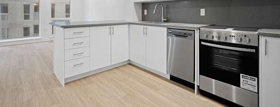 a kitchen with white cabinets and stainless steel appliances