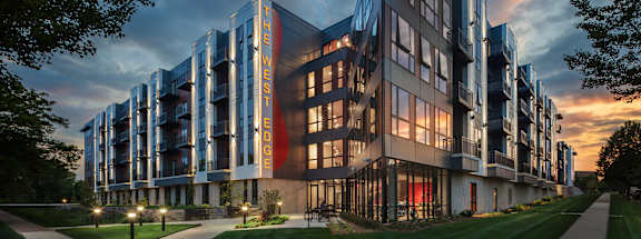 a rendering of a large building with a sunset in the background