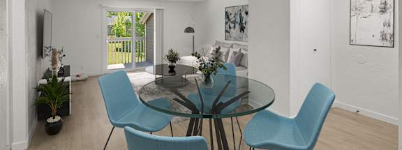 a living room with a glass table and blue chairs