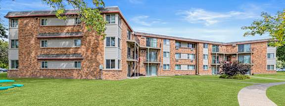 A large grassy area in front of a brick building.