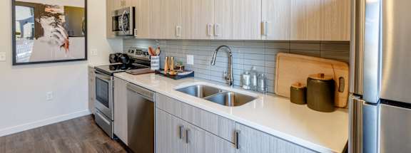A modern kitchen with stainless steel appliances and wooden cabinets.