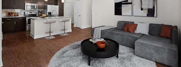 A modern living room with a grey couch and a black coffee table.