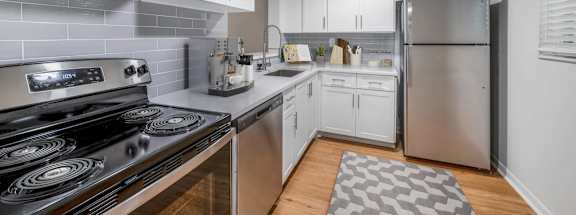 a kitchen with white cabinets and stainless steel appliances