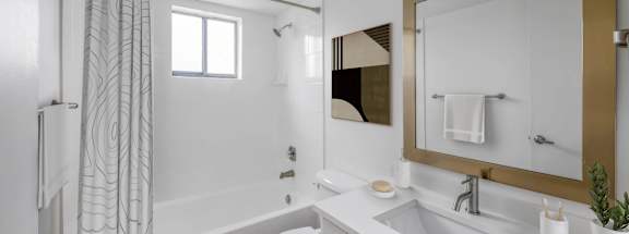 a bathroom with a white sink and toilet and a white bathtub