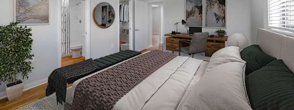 a bedroom with a bed and a desk in a room
