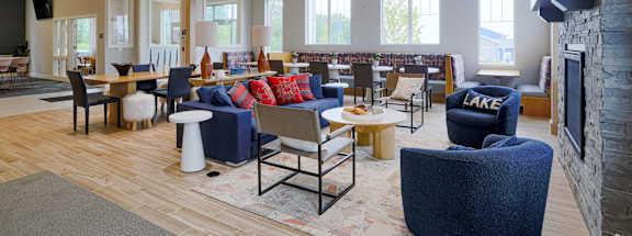 a lobby with couches chairs and tables and a fireplace