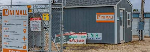 A sign for the Cini Mall is displayed in front of a small building.
