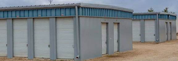 A series of storage units with closed grey doors are lined up in a row.