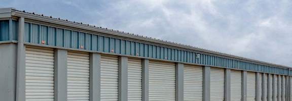 A long row of storage units with grey doors and blue trim.