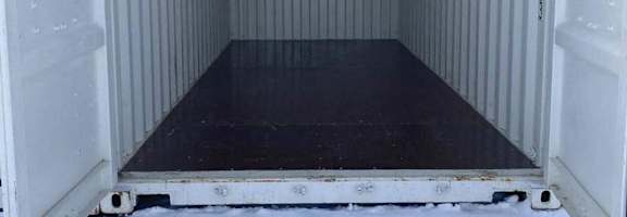 The image shows the empty inside of a white shipping container.