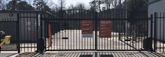 A gated entrance to a rental property with a sign that reads "Rent Now".