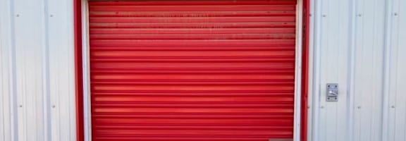 a red garage door in front of a white building