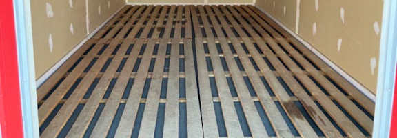 the inside of a storage room with wooden floors and walls