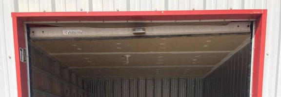 A red and white storage unit with a metal door.