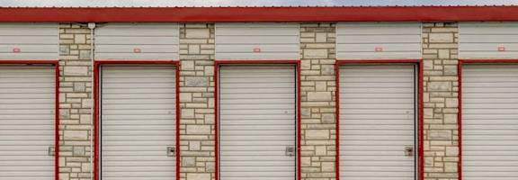 A row of garage doors with a red and white striped border.