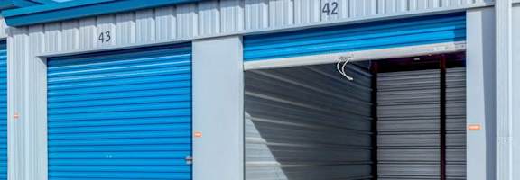 A blue and white storage facility with doors numbered 42 and 43.