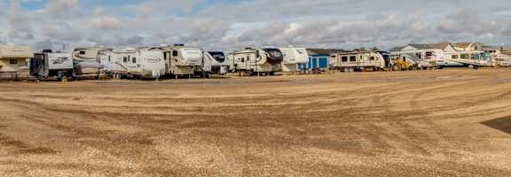 A field with a row of RVs parked in the distance.