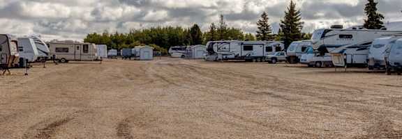 A field with a few RVs and trees in the background.