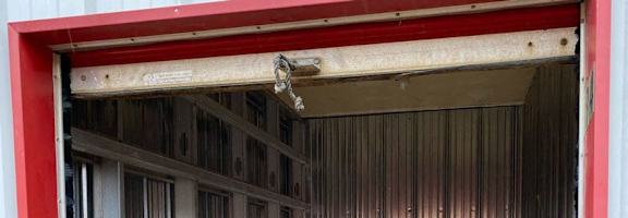 A red and white garage door is open.