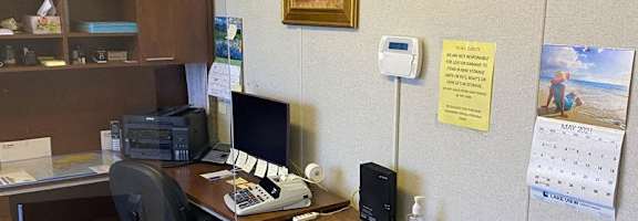 A small office with a desk, chair, and a clock on the wall.