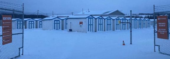 A snowy scene with a fence and a sign that says "BENT NOW".