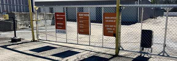 A fenced area with signs for renting and the main office.