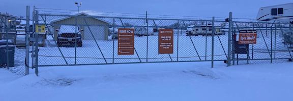 a yard with a chain link fence with signs on it