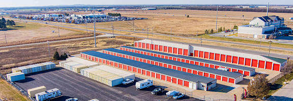 A large red and white building with a parking lot in front.