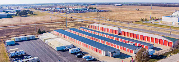 A large red and white building with a parking lot in front.