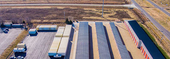 A parking lot with a long row of parked cars.