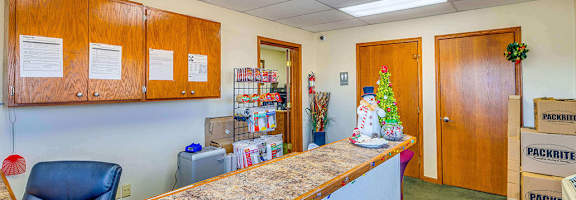 A reception area with a desk, chair, and holiday decorations.