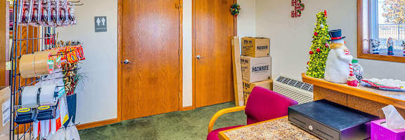 A room with a desk, chair, and a wall with a window.