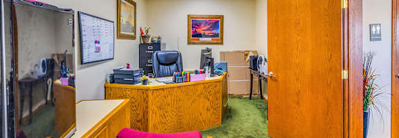 A reception area with a desk and a red chair.