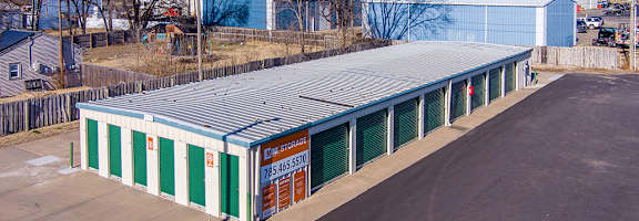 A large green and white storage building with a sign on it.