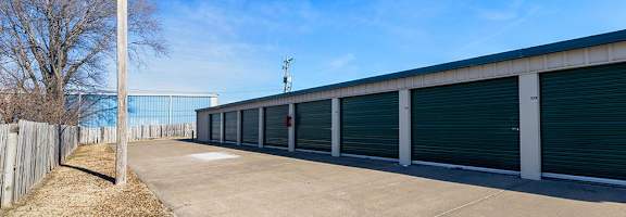 A long row of storage units with a clear blue sky above.
