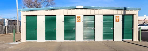 A building with green doors and a sign on the top.