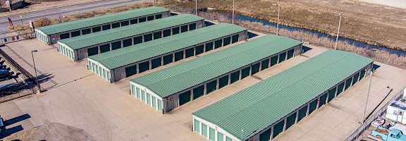 A large industrial area with green roofed buildings and a parking lot.