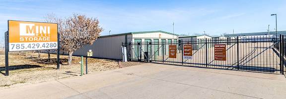 A storage facility named Mini Storage with a sign displaying the phone number 785.429.4280.