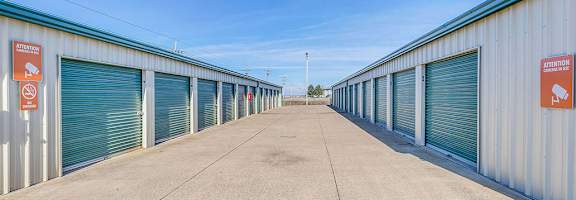 A long row of storage units with a sign on the wall.