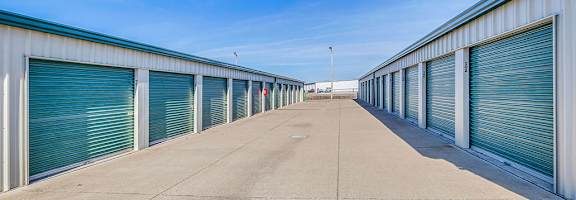 A long row of storage units with closed grey doors.