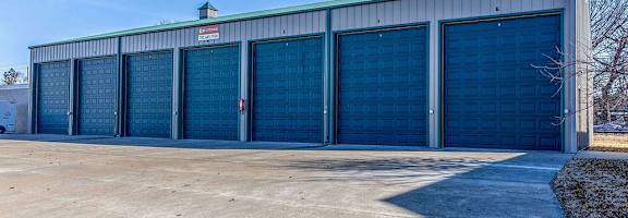 A large industrial building with a row of doors and windows.