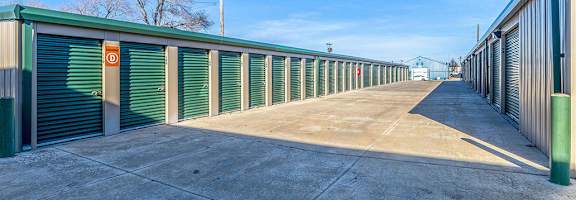A long row of green storage units with closed doors.
