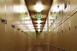 A long hallway with a green exit sign at the end.