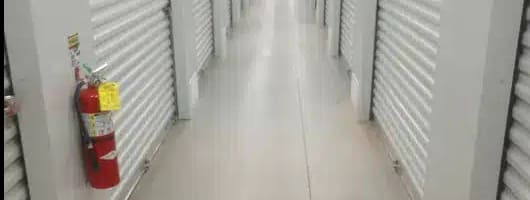 an empty hallway with doors and a fire hydrant on the wall