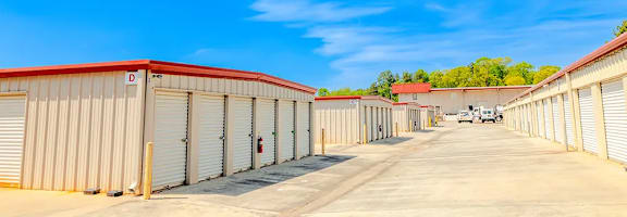 a row of sheds in a parking lot with a blue sky