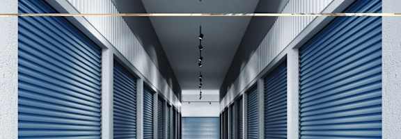 A long hallway with blue rolling doors on both sides.