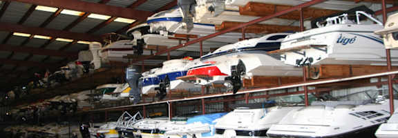 A boat lift is holding a boat up in a boat storage facility.