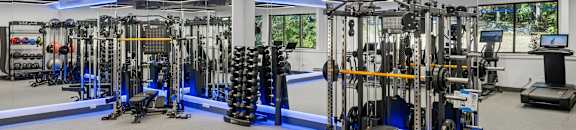 A gym with a variety of equipment including weights and machines.